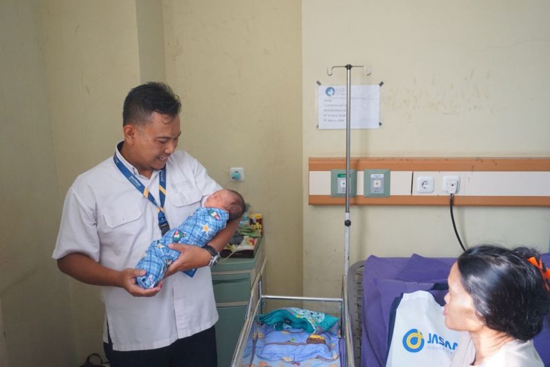 Lahiran di Tol: Seorang petugas Jasa Marga menggendong bayi
