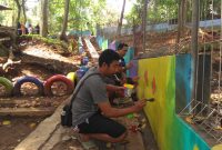 salah satu warga melukis dinding dengan kreatif.