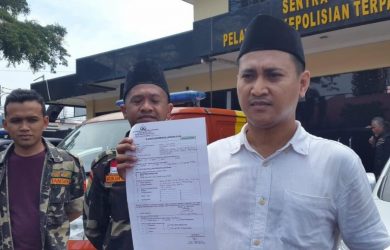 Caleg Golkar Hasan Muhtar menunjukkan surat laporan.