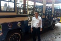 Ketua DPC Organda Kota Bekasi, Ahmad Juaini saat berpose di depan bus pariwisata.
