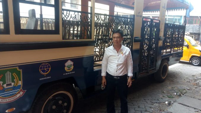 Ketua DPC Organda Kota Bekasi, Ahmad Juaini saat berpose di depan bus pariwisata.
