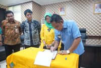 Foto: Bupati Bekasi, Eka Supria Atmaja melakukan penandatanganan MoU Program Layan Antar Dokumen Adminduk antara Pemkab Bekasi dengan PT. Pos Indonesia