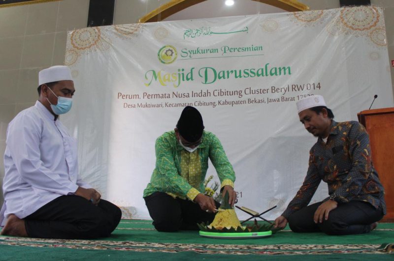 Simbolis: Kepala Desa Muktiwari Bahrudin SE memotong nasi tumpeng sebagai salah satu simbol peresmian masjid darussalam, Sabtu (1/5/2021).