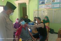 Kepala Desa Muktiwari, Bahrudin, S.E. Memonitoring Vaksinasi Massal di Kantor Desa Muktiwari, pada Jumat (9/9/2021).