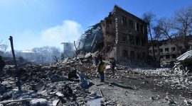 Orang-orang berdiri di depan pabrik sepatu yang hancur setelah serangan rudal, di tengah invasi Rusia, di Dnipro, Ukraina 12 Maret 2022. Pasukan Rusia meningkatkan tembakan jarak jauh di Mariupol, Kyiv, Kharkiv, Chernihiv dan pusat populasi lainnya di Ukraina. REUTERS/Mykola Synelnikov

