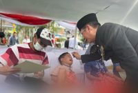 Foto : Pj Bupati Bekasi Dani Ramdan sedang mengibur salah satu anak yang disunat pada Hari jadi Kabupaten bekasi yang ke-72 di Plaza Pemda, Komplek Pemkab Bekasi, Kecamatan Cikarang Pusat, pada Senin (15/07/2022). 