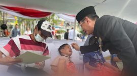 Foto : Pj Bupati Bekasi Dani Ramdan sedang mengibur salah satu anak yang disunat pada Hari jadi Kabupaten bekasi yang ke-72 di Plaza Pemda, Komplek Pemkab Bekasi, Kecamatan Cikarang Pusat, pada Senin (15/07/2022). 