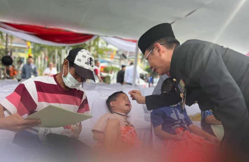 Foto : Pj Bupati Bekasi Dani Ramdan sedang mengibur salah satu anak yang disunat pada Hari jadi Kabupaten bekasi yang ke-72 di Plaza Pemda, Komplek Pemkab Bekasi, Kecamatan Cikarang Pusat, pada Senin (15/07/2022). 