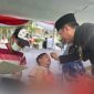 Foto : Pj Bupati Bekasi Dani Ramdan sedang mengibur salah satu anak yang disunat pada Hari jadi Kabupaten bekasi yang ke-72 di Plaza Pemda, Komplek Pemkab Bekasi, Kecamatan Cikarang Pusat, pada Senin (15/07/2022). 