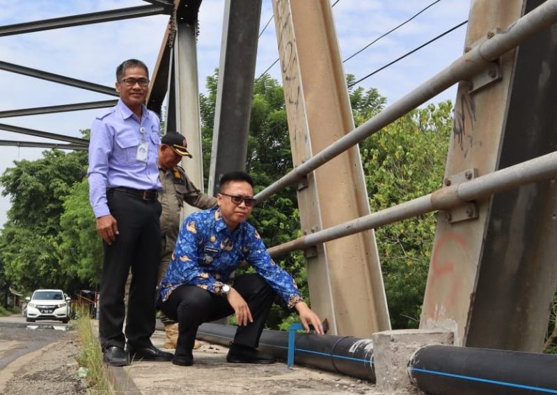 PERBAIKAN : Camat Cibarusah bersama Kepala Kantor Cabang Perusahaan Daerah Air Minum (PDAM) cabang Cibarusah, meninjau pemindahan pipa aliran air PDAM ke bahu Jembatan Cipamingkis.
