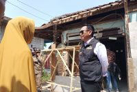 Pj Bupati Bekasi Dani Ramdan berinteraksi dengan salah satu warga yanag berhak menerima bantuan Rehabilitasi Rumah Tidak Layak Huni (Rutilahu).