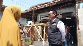 Pj Bupati Bekasi Dani Ramdan berinteraksi dengan salah satu warga yanag berhak menerima bantuan Rehabilitasi Rumah Tidak Layak Huni (Rutilahu).