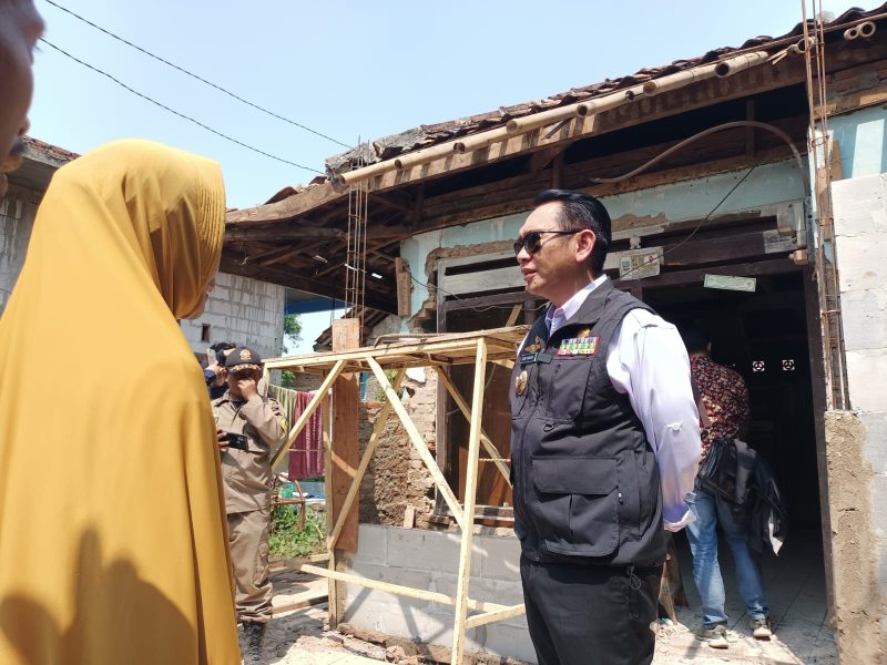 Pj Bupati Bekasi Dani Ramdan berinteraksi dengan salah satu warga yanag berhak menerima bantuan Rehabilitasi Rumah Tidak Layak Huni (Rutilahu).