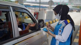 Petugas : Petugas jasa marga terlihat membantu transaksi e-toll guna untuk memperlancar penggunaan tol.