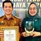 Penghargaan: Lurah Jatirangga Ahmad Apandi saat di dampingi istrinya.