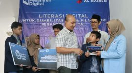 Juru Bahasa Isyarat (kanan), sedang menjurubahasakan kegiatan yang sedang berlangsung kepada dua orang santri disabilitas tuli dari Rumah Qur’an Isyaroh (kiri - tengah), di Bandung, Sabtu (20/7). XL Axiata berkomitmen dalam mendorong peningkatan kompetensi digital para penyandang disabilitas di berbagai daerah.