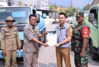 epala Bidang Informasi dan Komunikasi Publik (IKP) Diskominfosantik Kabupaten Bekasi, Rhamdan Nurul Ikhsan, secara simbolis menyerahkan bantuan 10.000 liter air bersih untuk warga Desa Hurip Jaya, di Halaman Kantor Kecamatan Babelan, pada Selasa, (24/09/2024). 