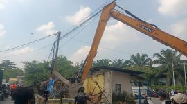 Alat berat dikerahkan dalam proses penertiban bangunan liar di kawasan Jalan Inspeksi Kalimalang, Desa Gandasari, Kabupaten Bekasi, Rabu (4/6/2025). Satpol PP bersama aparat gabungan menindak tegas bangunan semi permanen yang melanggar aturan zonasi.