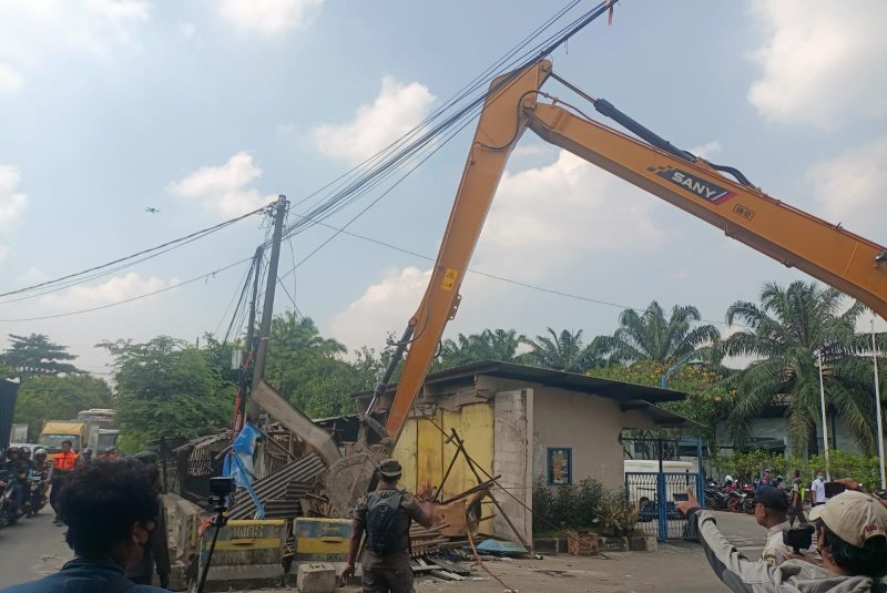Alat berat dikerahkan dalam proses penertiban bangunan liar di kawasan Jalan Inspeksi Kalimalang, Desa Gandasari, Kabupaten Bekasi, Rabu (4/6/2025). Satpol PP bersama aparat gabungan menindak tegas bangunan semi permanen yang melanggar aturan zonasi.
