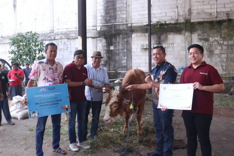 Kepala Dinas Lingkungan Hidup Kabupaten Bekasi Donny Sirait (kedua dari kanan) secara simbolis menerima satu ekor sapi kurban dari perwakilan PT Lippo Cikarang dalam program penyaluran hewan kurban melalui CSR, di Cikarang, Kamis (5/6/2025). 
