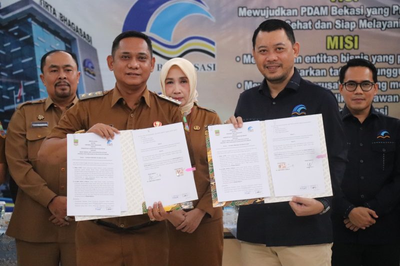 Wakil Bupati Bekasi, dr. Asep Surya Atmaja, bersama Direktur Utama Perumda Tirta Bhagasasi, Reza Lutfi, menunjukkan dokumen serah terima aset wilayah layanan Cabang Rawalumbu dan Cabang Pembantu Setiamekar di Kantor Pusat Tirta Bhagasasi, Cikarang Pusat, Senin (23/6/2025). Penyerahan aset ini menjadi langkah strategis dalam penataan dan optimalisasi tata kelola aset antarpemerintah daerah.

