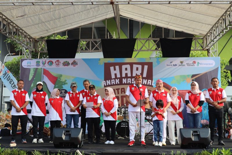 Wali Kota Bekasi, Tri Adhianto (berpeci merah dengan motif batik), bersama jajaran Pemerintah Kota Bekasi dan tamu undangan menghadiri peringatan Hari Anak Nasional 2025 tingkat Kota Bekasi. Acara digelar meriah di panggung utama dengan semangat kolaborasi untuk mewujudkan Sekolah Ramah Anak dan mencegah kekerasan terhadap anak sejak dini, Minggu (27/7/2025).