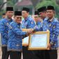 Asisten Administrasi Umum (Asda III) Sekretariat Daerah Kabupaten Bekasi, Jaoharul Alam (kiri depan), menyerahkan piagam penghargaan dari Kementerian PAN-RB kepada perwakilan perangkat daerah yang meraih predikat tinggi dalam pelayanan publik, dalam upacara peringatan Hari Koperasi Nasional ke-78 dan Upacara Korpri di Plaza Pemkab Bekasi, Cikarang Pusat, Kamis (17/07/2025). Pemerintah Kabupaten Bekasi meraih penghargaan nasional di bidang pelayanan publik untuk RSUD, Disdukcapil, dan Dinas Sosial.

