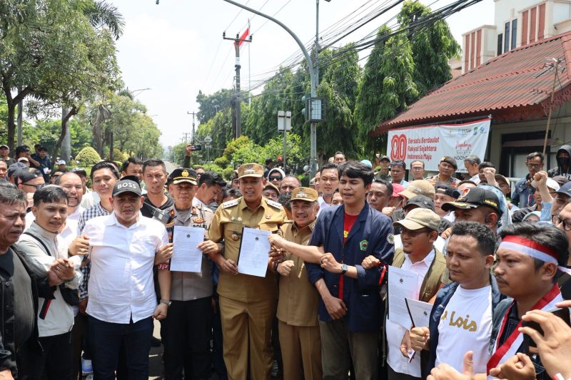 Wali Kota Bekasi Tri Adhianto bersama Wakil Wali Kota Abdul Harris Bobihoe, Forkopimda, dan perwakilan massa aksi menunjukkan hasil kesepakatan aspirasi di depan Kantor DPRD Kota Bekasi, Senin (1/9/2025).