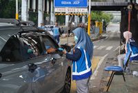 Petugas Jasa Marga menggunakan perangkat mobile reader untuk melayani transaksi sementara di Gerbang Tol Dalam Kota Jakarta, pasca pemulihan layanan akibat insiden kebakaran, Senin (1/9/2025).
