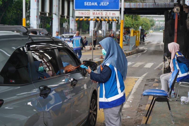 Petugas Jasa Marga menggunakan perangkat mobile reader untuk melayani transaksi sementara di Gerbang Tol Dalam Kota Jakarta, pasca pemulihan layanan akibat insiden kebakaran, Senin (1/9/2025).
