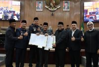 Wali Kota Bekasi Tri Adhianto bersama pimpinan DPRD Kota Bekasi menunjukkan dokumen hasil penandatanganan Perubahan KUA-PPAS Tahun Anggaran 2025 dalam rapat paripurna di Gedung DPRD Kota Bekasi, Selasa (2/9/2025).

