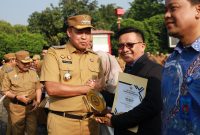 Wali Kota Bekasi, Tri Adhianto Tjahyono, menyerahkan penghargaan Sekolah Adiwiyata Tingkat Kota Bekasi Tahun 2025 kepada perwakilan SMA Ananda dalam apel di Plaza Kantor Wali Kota Bekasi, Senin (22/9/2025). Penghargaan ini diberikan kepada sekolah-sekolah yang berhasil mewujudkan lingkungan belajar bersih, sehat, dan berwawasan lingkungan.
