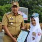 Wali Kota Bekasi Tri Adhianto menyerahkan penghargaan kepada siswi berprestasi, Emily Ravdanty Laras, pada apel pagi Pemkot Bekasi, Senin (15/9/2025).