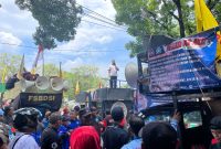 Wali Kota Bekasi Tri Adhianto berdiri di atas mobil komando saat berdialog dengan massa buruh dari Aliansi Buruh Bekasi Melawan (BBM) yang menggelar aksi di depan Kantor Pemerintah Kota Bekasi, Kamis (30/10/2025). Para buruh menuntut kenaikan UMK 2026 sebesar 10–15 persen dan pencabutan PP Nomor 35 Tahun 2021.