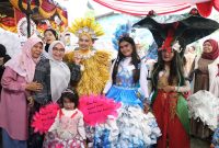 Ketua Forum Kota Bekasi Sehat bersama warga Kelurahan Harapan Jaya berpose dengan para peserta fashion show kreasi daur ulang yang mengenakan kostum unik berbahan sampah plastik, kertas, dan kemasan bekas dalam rangka Launching Kampung Komposter, Kamis (4/12/2025).
