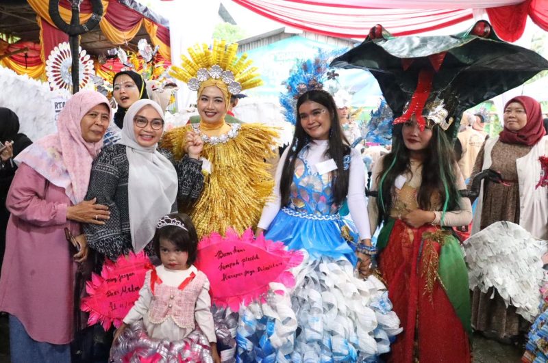 Ketua Forum Kota Bekasi Sehat bersama warga Kelurahan Harapan Jaya berpose dengan para peserta fashion show kreasi daur ulang yang mengenakan kostum unik berbahan sampah plastik, kertas, dan kemasan bekas dalam rangka Launching Kampung Komposter, Kamis (4/12/2025).
