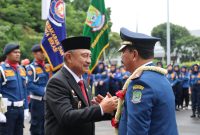 Wakil Wali Kota Bekasi Abdul Harris Bobihoe memberikan ucapan penghormatan kepada Kepala Dinas Pemadam Kebakaran dan Penyelamatan Kota Bekasi Abi Hurairah dalam apel purna tugas di Markas Komando Disdamkarmat Kota Bekasi.