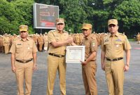 Wali Kota Bekasi menyerahkan piagam penghargaan kepada perwakilan perangkat daerah pada apel perdana Pemerintah Kota Bekasi tahun 2026, Senin (5/1/2026), sebagai bentuk apresiasi atas capaian kinerja, keterbukaan informasi publik, serta komitmen peningkatan pelayanan dan transformasi digital di lingkungan Pemkot Bekasi.