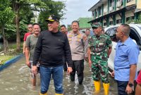 Wali Kota Bekasi Tri Adhianto bersama jajaran TNI, Polri, dan perangkat daerah meninjau langsung lokasi terdampak banjir di salah satu wilayah Kota Bekasi, Senin (18/01/2026). Peninjauan dilakukan untuk memastikan penanganan berjalan cepat, sekaligus memetakan langkah lanjutan guna meminimalkan dampak banjir dan menjaga keselamatan warga.