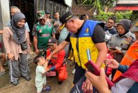 Wali Kota Bekasi Tri Adhianto berinteraksi dengan anak warga saat meninjau lokasi banjir di Gang Mawar, Kelurahan Margahayu, Kecamatan Bekasi Timur, Jumat (30/1/2026).