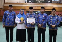 Wali Kota Bekasi Tri Adhianto bersama jajaran Pemerintah Kota Bekasi saat menerima penghargaan Universal Health Coverage (UHC) kategori Madya dari pemerintah pusat dalam Apel Gabungan di Balai Patriot, Senin (9/2/2026).