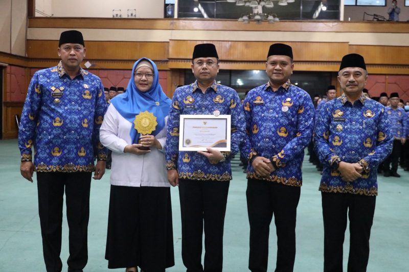 Wali Kota Bekasi Tri Adhianto bersama jajaran Pemerintah Kota Bekasi saat menerima penghargaan Universal Health Coverage (UHC) kategori Madya dari pemerintah pusat dalam Apel Gabungan di Balai Patriot, Senin (9/2/2026).