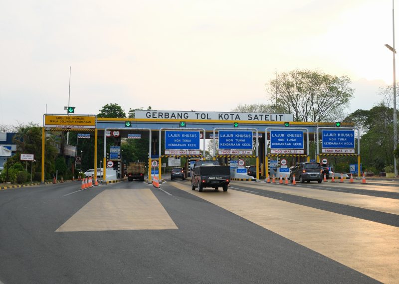 Kendaraan melintas di Gerbang Tol Kota Satelit pada Ruas Tol Surabaya–Gempol di Surabaya, Jawa Timur. PT Jasamarga Transjawa Tol tengah melakukan pekerjaan pelebaran lajur untuk meningkatkan kapasitas jalan dan memperlancar arus lalu lintas menjelang periode mudik. 