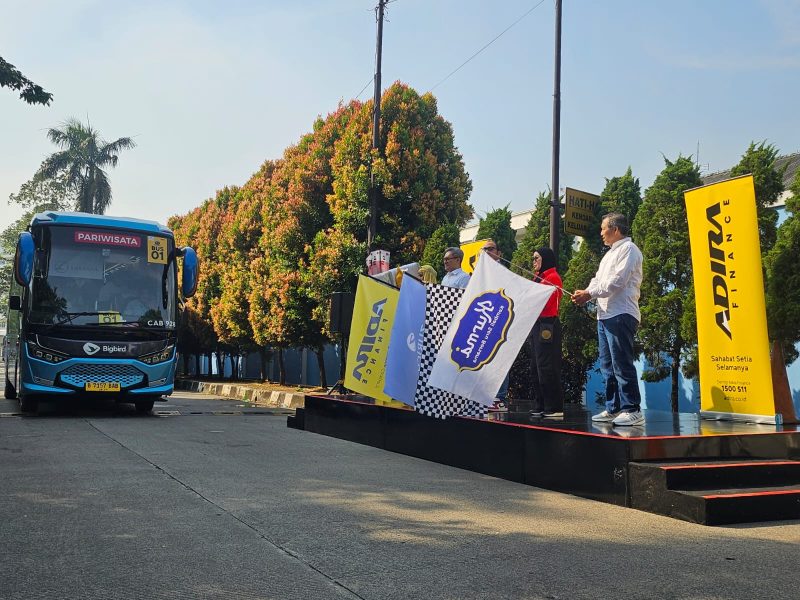 Keterangan Foto: Perwakilan Adira Finance melepas keberangkatan peserta program Mudik Gratis KURMA 2026 dengan pengibaran bendera, Rabu (18/3/2026). Sebanyak 300 pemudik diberangkatkan menggunakan bus menuju Solo dan Yogyakarta dengan berbagai fasilitas pendukung untuk perjalanan yang aman dan nyaman.