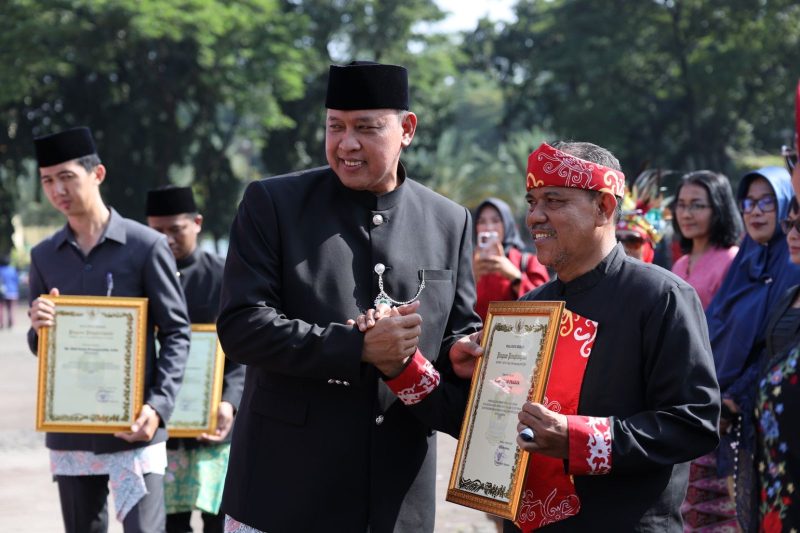 Wali Kota Bekasi menyerahkan penghargaan kepada salah satu pelaku seni budaya dalam upacara peringatan Hari Jadi ke-29 Kota Bekasi di Plaza Pemerintah Kota Bekasi, Selasa (10/3/2026). Penghargaan diberikan sebagai bentuk apresiasi atas kontribusi dalam melestarikan dan mengembangkan seni budaya daerah.
