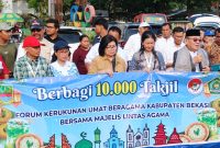 Ketua FKUB Kabupaten Bekasi Mubarok Nuri bersama pengurus dan relawan membagikan takjil kepada pengendara di kawasan Stadion Wibawamukti sebagai bentuk kepedulian dan mempererat kerukunan antarumat beragama di bulan Ramadan.