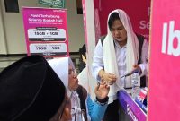 Petugas PT XLSMART Telecom Sejahtera Tbk melayani calon jemaah haji yang membeli paket komunikasi khusus di posko embarkasi.