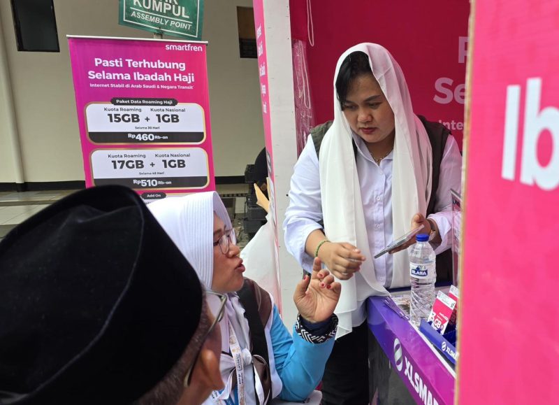 Petugas PT XLSMART Telecom Sejahtera Tbk melayani calon jemaah haji yang membeli paket komunikasi khusus di posko embarkasi.