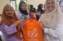 Petugas Dinas Perikanan Kabupaten Bekasi membagikan ikan kepada warga dalam program peningkatan konsumsi ikan untuk pencegahan stunting.