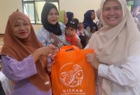 Petugas Dinas Perikanan Kabupaten Bekasi membagikan ikan kepada warga dalam program peningkatan konsumsi ikan untuk pencegahan stunting.